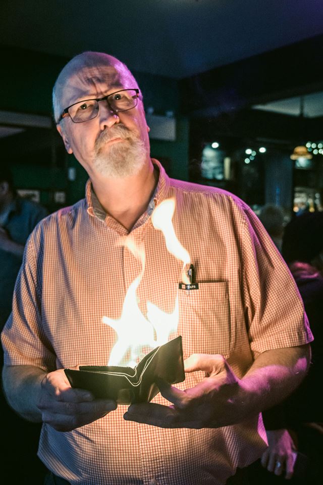 Man telling story with a book on fire