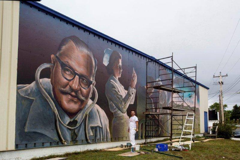 Pulse Of The Community mural in Botwood, with muralist Charlie Johnston at work