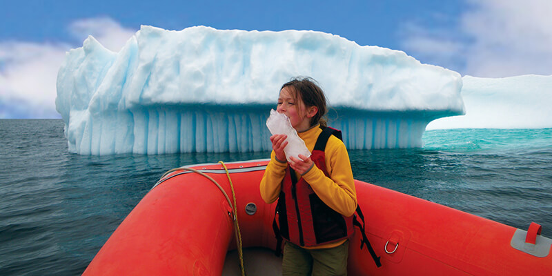 girl in boat near iceberg